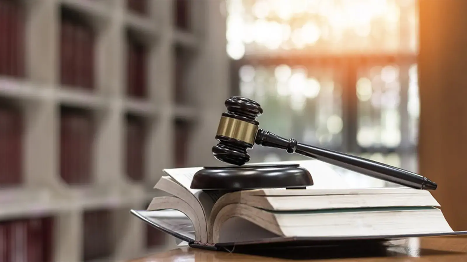 Aumentan las causas ingresadas al poder judicial en el primer semestre. Libro con un mazo de juez encima.