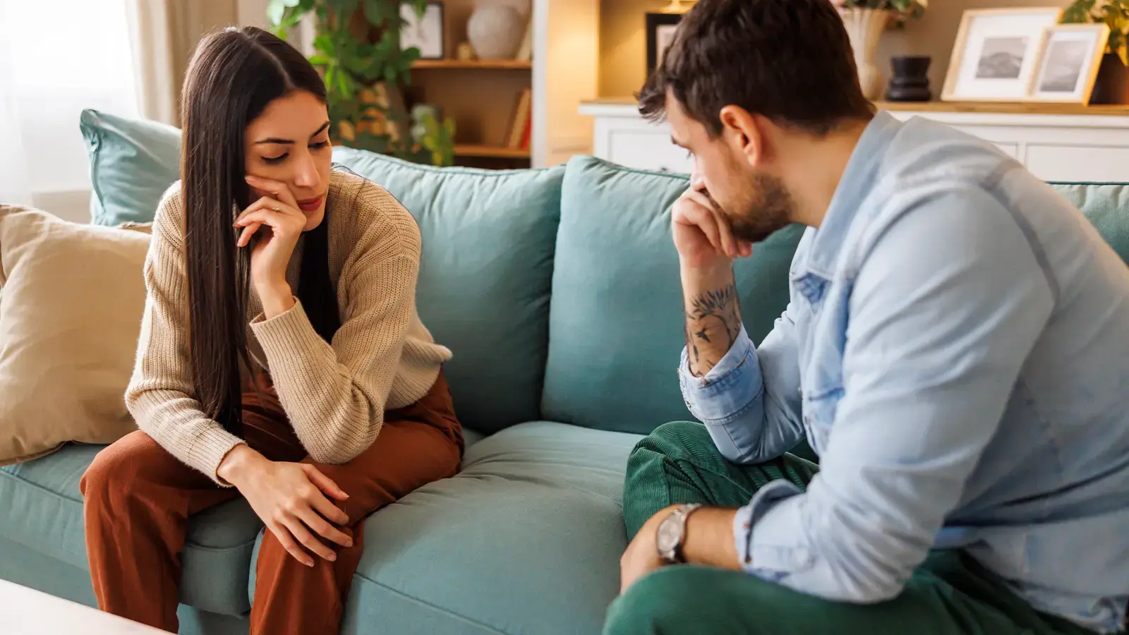 Cese de convivencia. Pareja triste sentada en un sofá