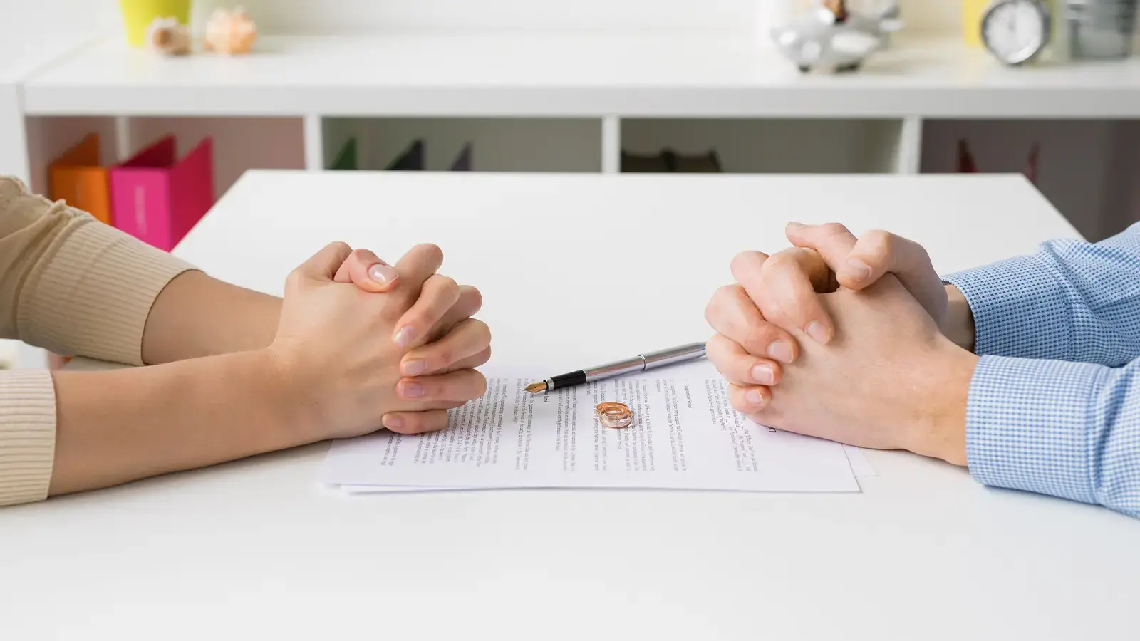 Cese de convivencia. Pareja frente a frente con documento por firmar al medio