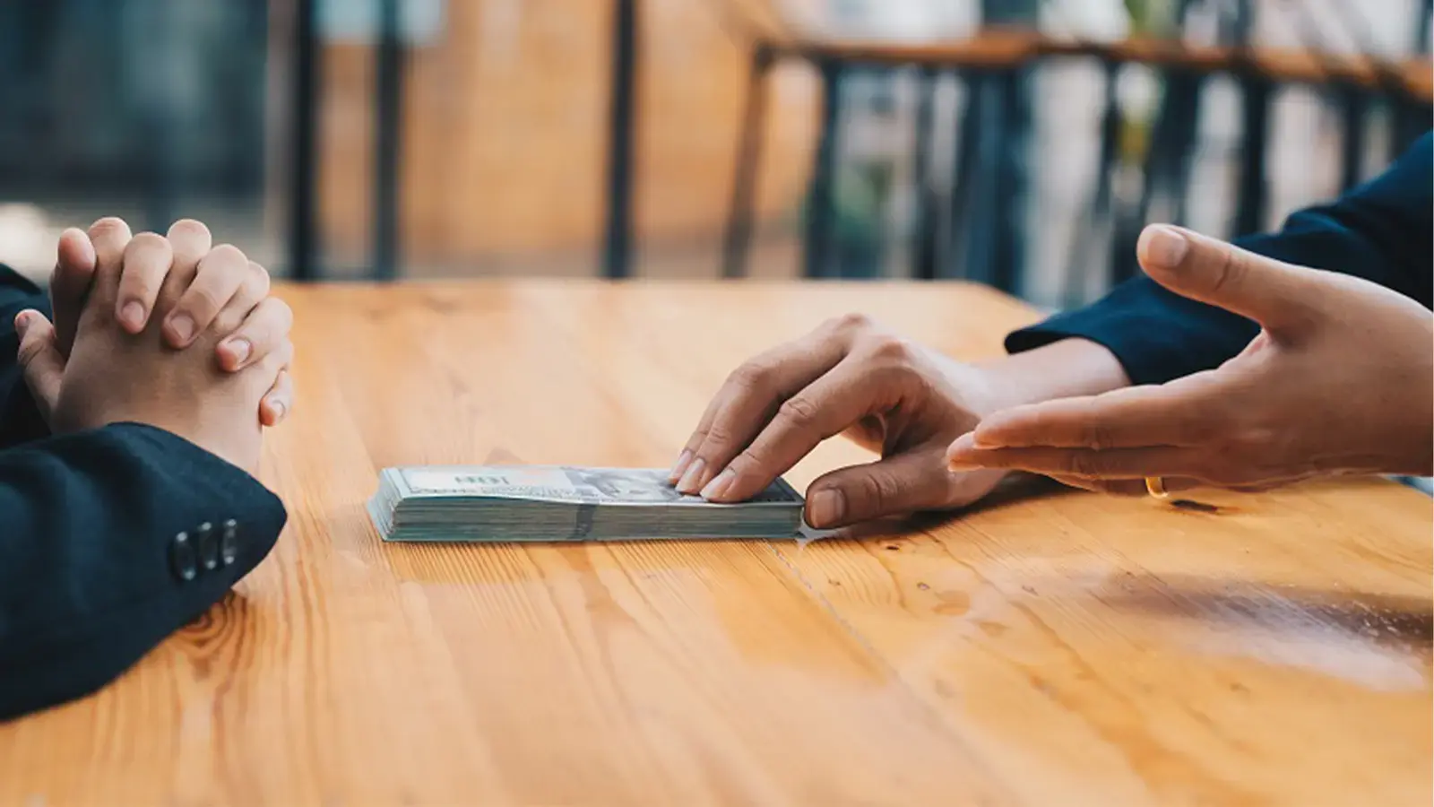 Créditos informales. Persona entregando fajo de billetes a otra
