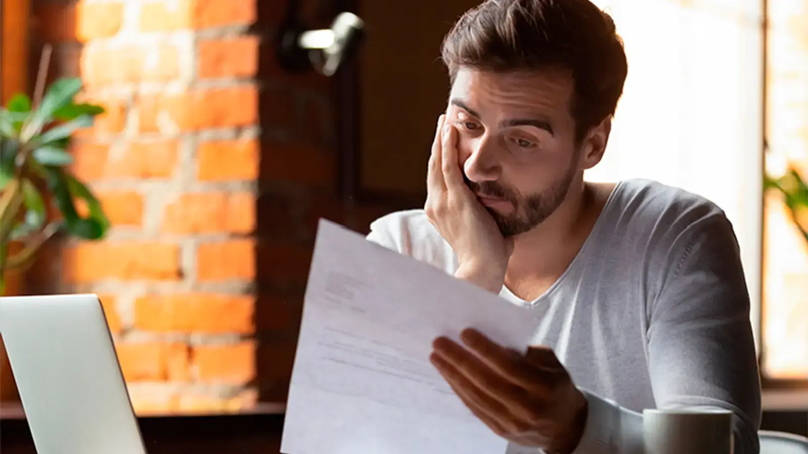 Problemas financieros. Hombre mirando una hoja de papel