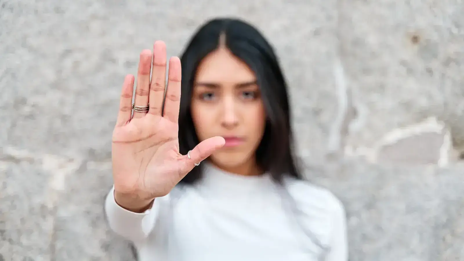 Erradicación de la violencia contra las mujeres. Mujer haciendo señal de alto con la mano.