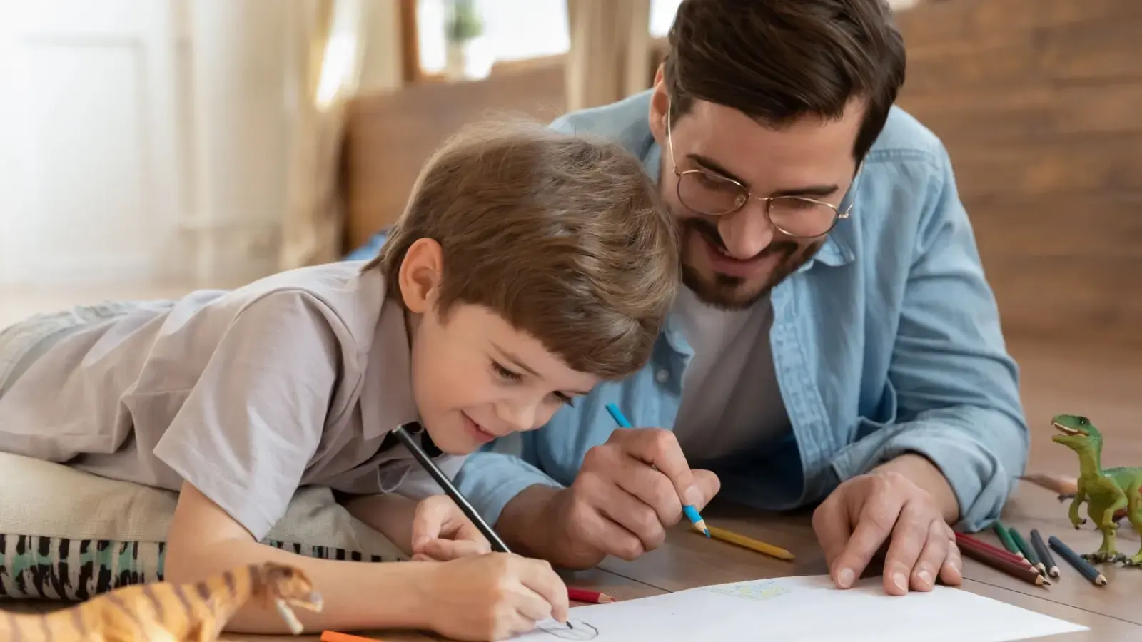 Cuidado personal de los hijos. Padre e hijo dibujando juntos.