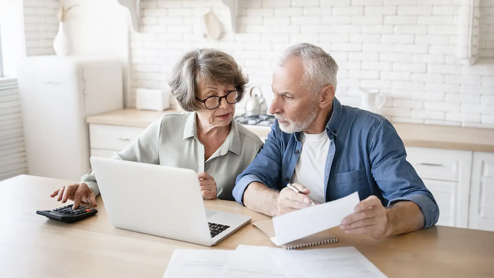 ¿Las deudas se heredan? Adultos mayores revisando un documento y un computador
