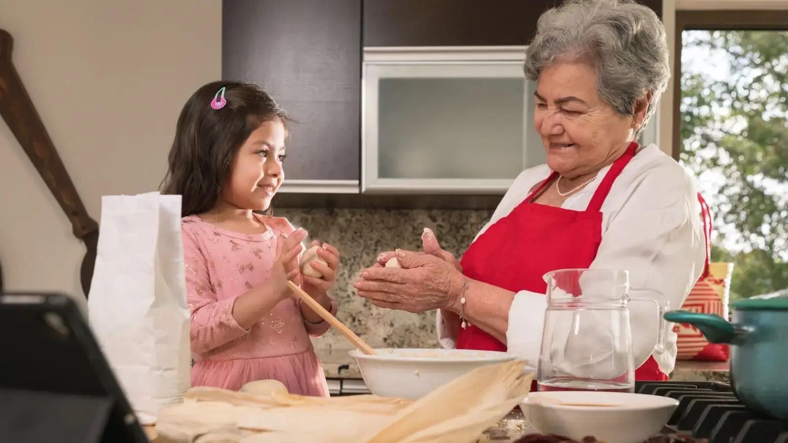 Cuidado personal nietos. Abuela y nieta cocinando juntas.