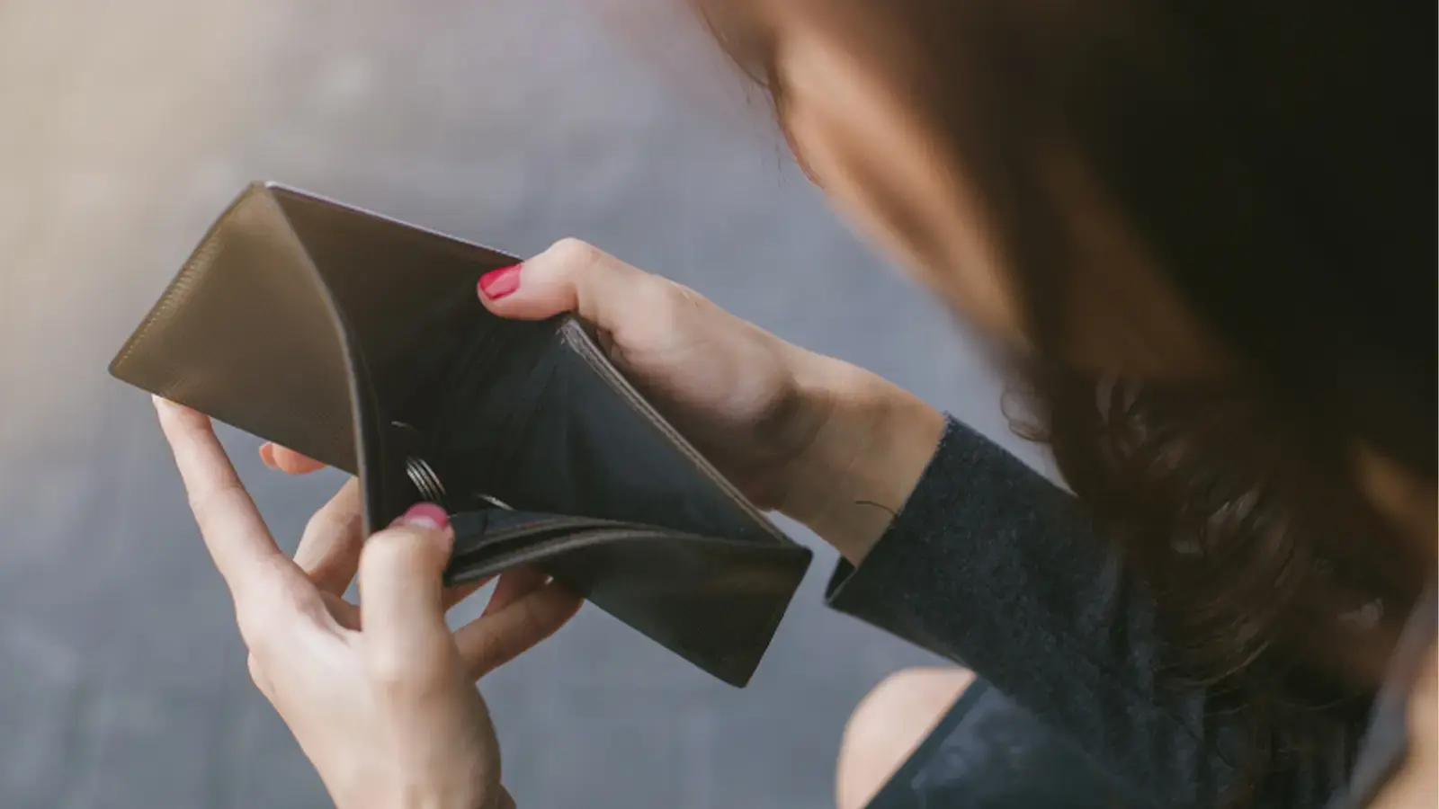 Ley de quiebras. Mujer mirando una billetera vacía