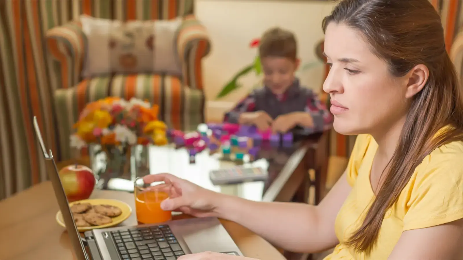 Pensión de alimentos. Madre mirando computador en casa con su hijo