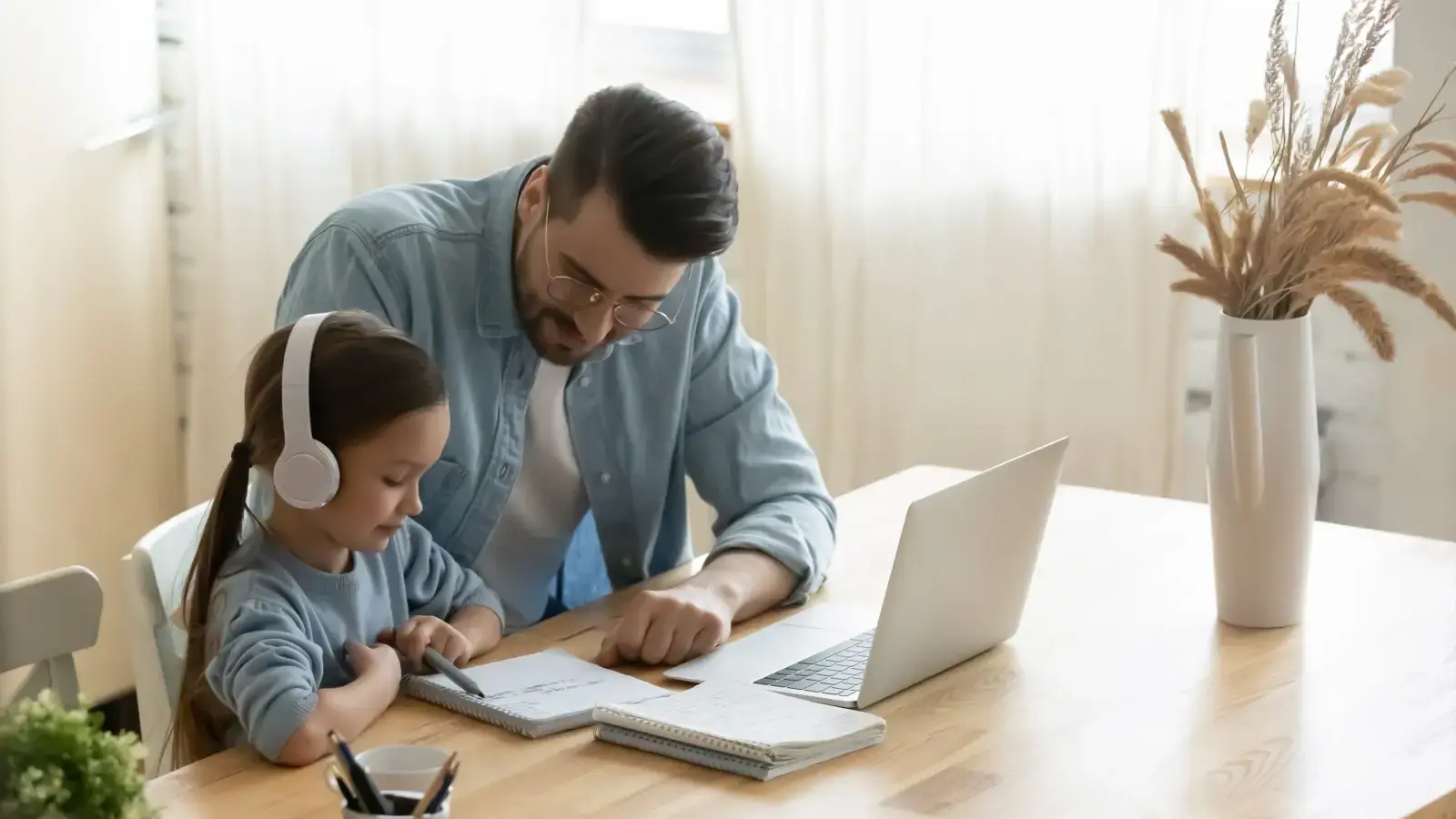 Relación directa y regular. Padre e hija sentados frente a un computador.